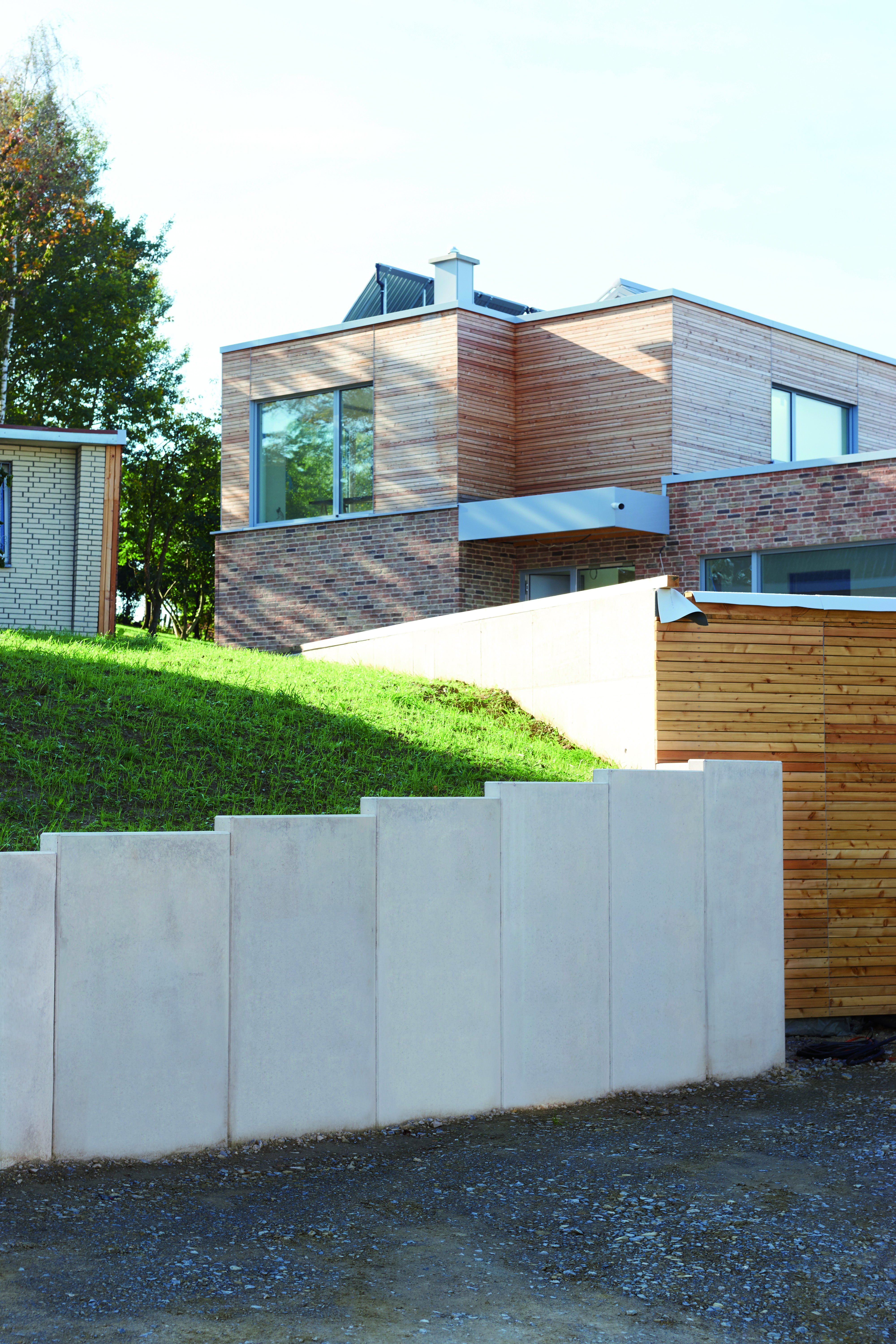 [Translate to Polski:] mit Winkelstützen abgestützter Hand vor Einfamilienhaus