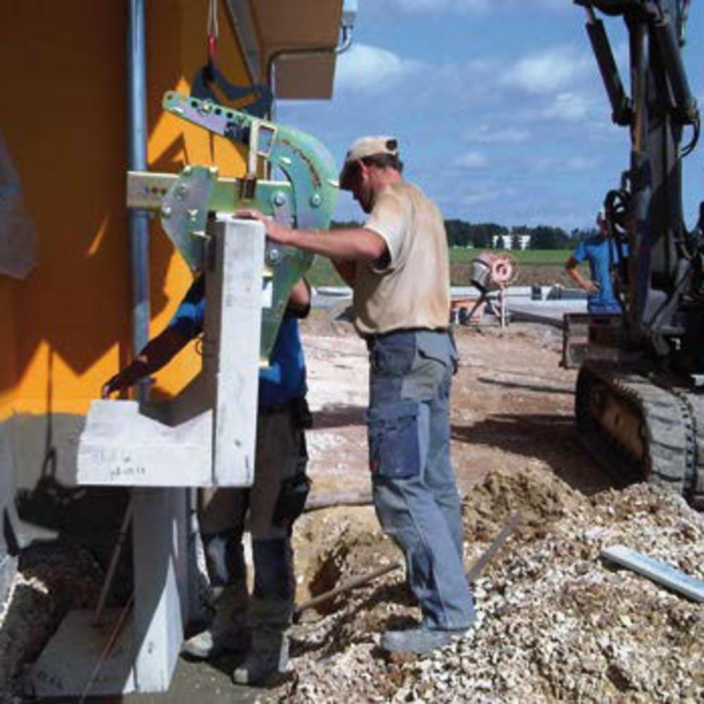 Pracownik pozycjonujący kątownik na placu budowy