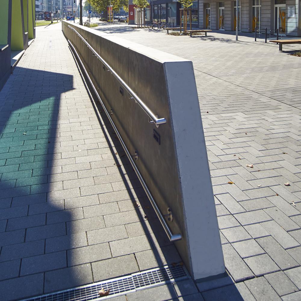 [Translate to Polski:] Betontrennwand angeschrägt mit Geländer