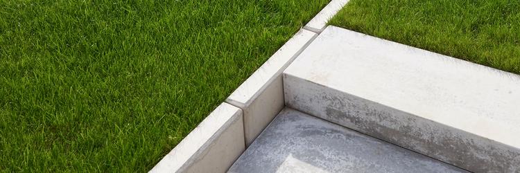 Trawnik z betonową krawędzią i stopniami