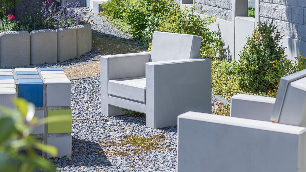 Grupa betonowych krzeseł na żwirze