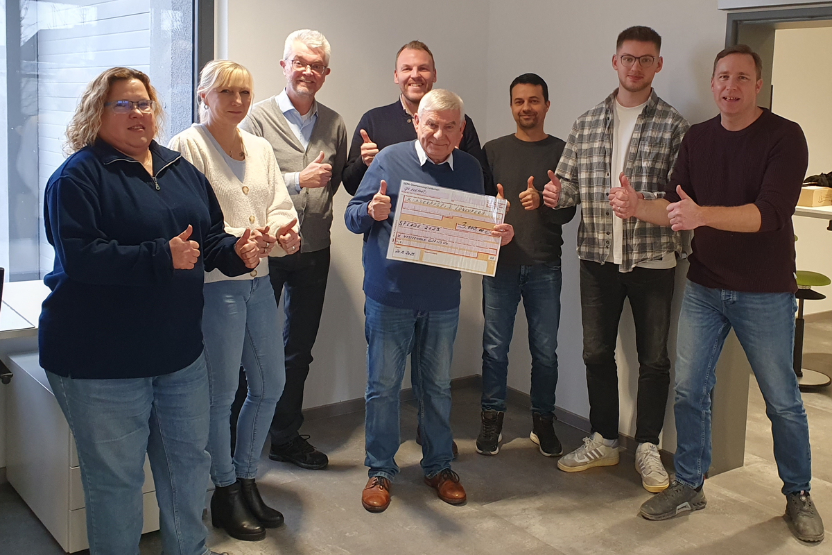 [Translate to Polski:] Gruppenbild mit Scheck