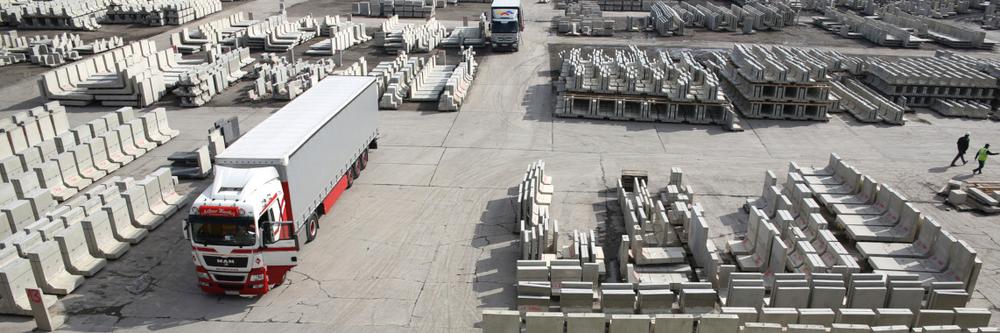 [Translate to Polski:] LKW steht zwischen vielen Betonfertigteilen